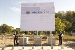 Gleich enthüllen BImA-Vorstandsmitglied Paul Johannes Fietz und der Präsident des Bundespolizeipräsidiums Dr. Dieter Romann (v. l.) das Bauschild.