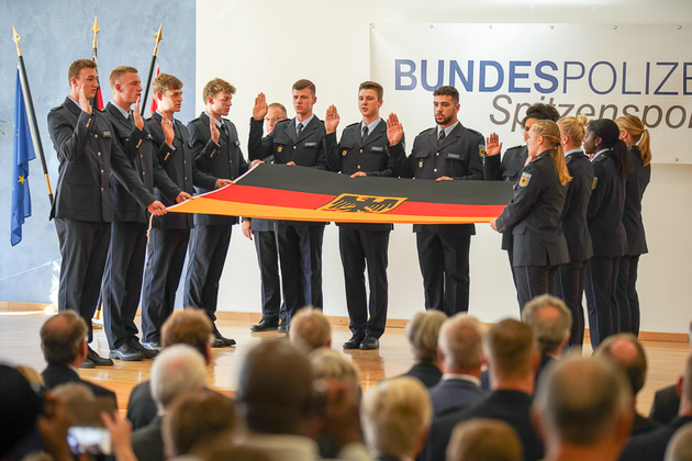 Die Dienstanfängerinnen und Dienstanfänger der Bundespolizeisportschule Kienbaum leisten den Eid an der Fahne.
