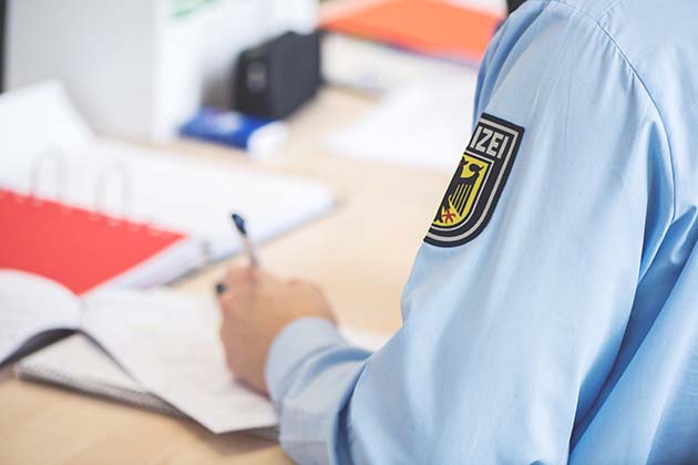 Bundespolizist schreibt auf Papier